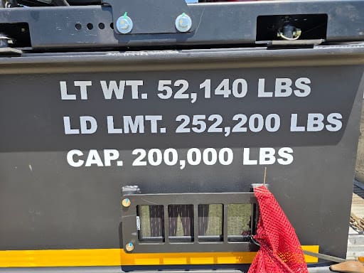 Close-up of the Machinery Cart load data plate showing 200,000 lb capacity and load limits.